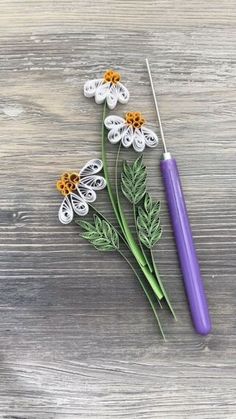 some flowers are sitting next to an umbrella on a wooden table with scissors and thread