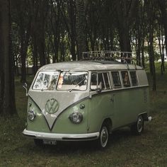 an old vw bus is parked in the woods