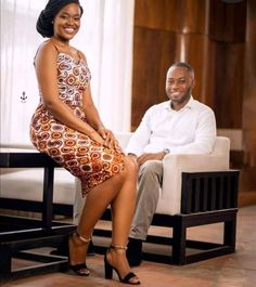 a man sitting next to a woman on a couch in front of a white chair