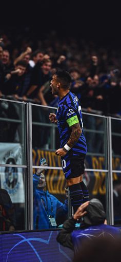 a soccer player is standing on the sidelines in front of an audience at a game