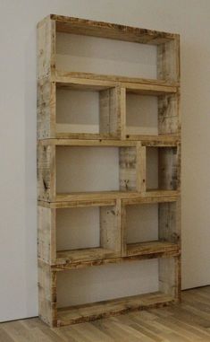 a wooden shelf sitting on top of a hard wood floor next to a white wall