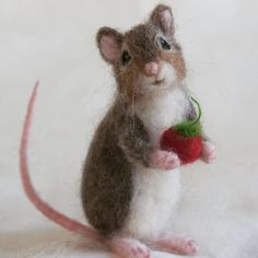 a needled mouse holding a red apple