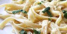 a plate of pasta with parsley on top