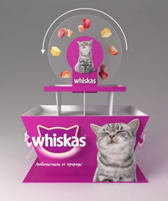 a cat sitting in front of a whiska's sign