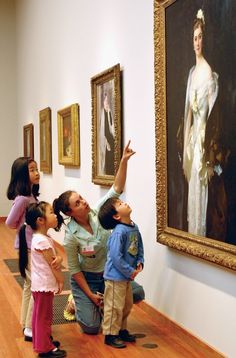 children are looking at paintings on the wall