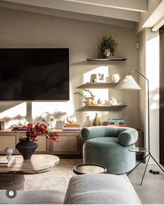 a living room filled with furniture and a flat screen tv mounted to the side of a wall