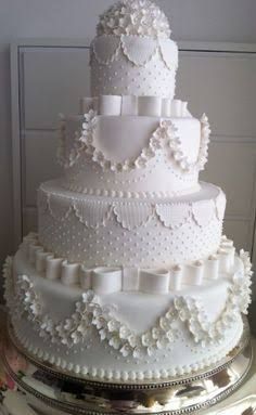 a large white wedding cake sitting on top of a table