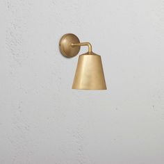 a brass wall light on a white wall