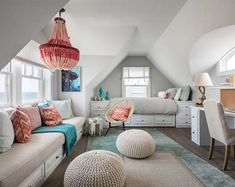 an attic bedroom with white walls and carpeted flooring is decorated in pastel colors