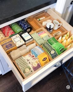 an open drawer in a kitchen filled with different types of food and drinks on top of it