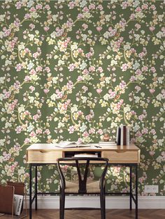 a desk and chair in front of a floral wallpaper