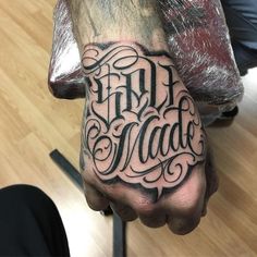 a man's hand with the word free made tattooed on it, in black ink