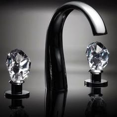 a black faucet with three crystal knobs