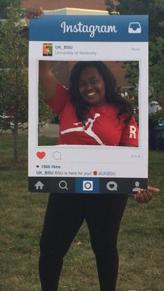 a woman holding up a poster with an instagram photo on it's front