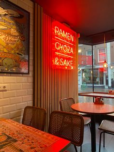 the inside of a restaurant with tables and chairs in front of a large window that reads ramon gyoza & saki