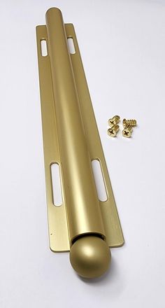 a gold door handle and screws on a white surface