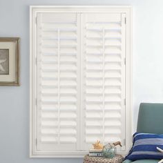 a room with blue walls and white shutters