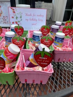 several plastic containers filled with candy and confection on top of a metal table