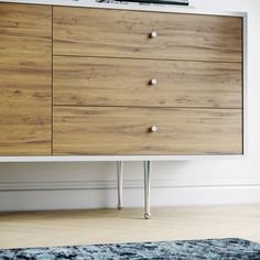 a large wooden dresser sitting on top of a hard wood floor next to a white wall