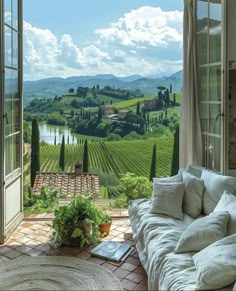 an open window with a view of the countryside and vineyards in front of it