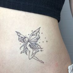 a woman's stomach with a fairy tattoo on her belly and stars around it