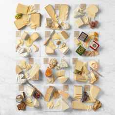 an assortment of cheeses arranged in squares on a marble counter top, with the number one