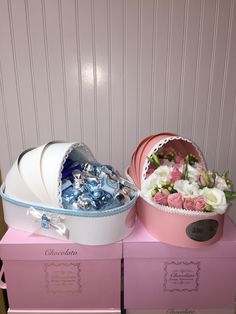 two pink boxes with white and blue flowers in them sitting on top of each other