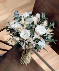 a bouquet of flowers sitting on top of a wooden chair