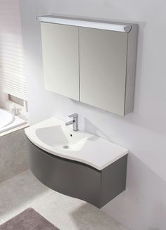 a bathroom sink sitting under a mirror next to a bathtub and toilet paper dispenser