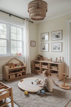 a baby sitting on the floor in front of a play table and bookshelf