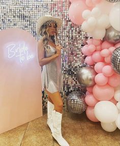 a woman standing in front of some balloons