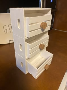 a white wooden drawer with corks on it