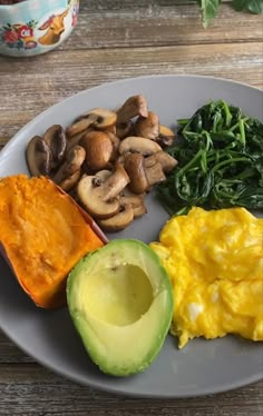 a white plate topped with eggs, spinach and mushrooms