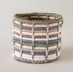 a woven basket sitting on top of a white table