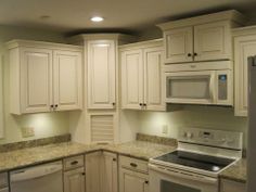 a kitchen with white cabinets and granite counter tops