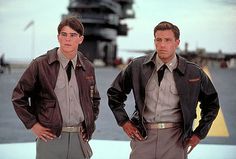 two men standing next to each other in front of an airplane