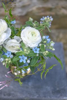 a vase filled with white and blue flowers