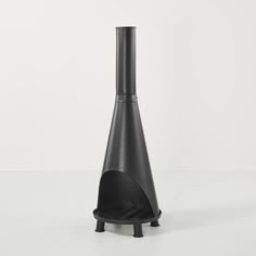 a tall black vase sitting on top of a white table