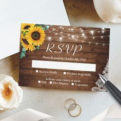 a wedding card with sunflowers and string lights on it next to a pen