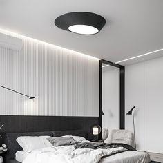 a large bed sitting under a ceiling light in a bedroom