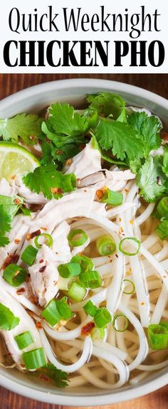 chicken pho noodle soup in a white bowl with cilantro and lime garnish