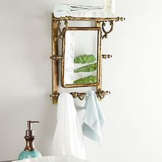 a bathroom sink with a mirror above it and towels hanging on the wall next to it