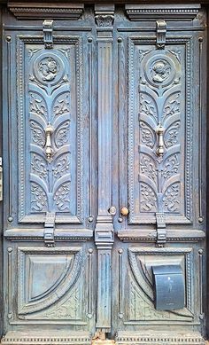 an old wooden door with ornate carvings on the front and side panels, which are painted blue