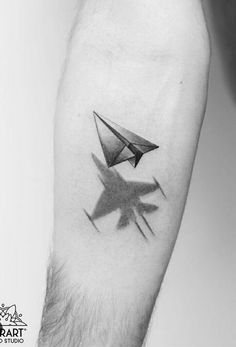 a black and white photo of a person's arm with an origami tattoo on