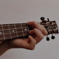 a person holding an acoustic guitar in their left hand and playing the fretset