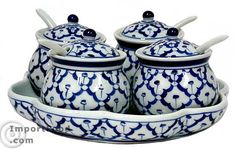 three blue and white pots with lids on a tray in the shape of a bowl