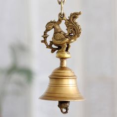 a golden bell with a bird on it