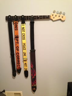 guitar straps are hanging on the wall next to an electric guitar and other musical instruments