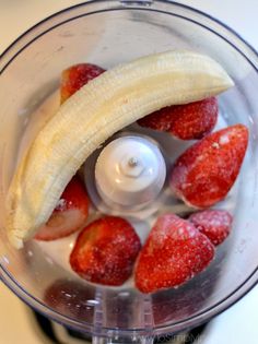 strawberries and bananas in a food processor ready to be blended into juice or something else