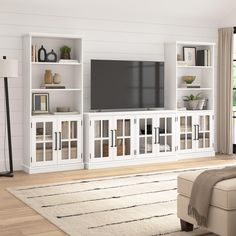 a living room filled with furniture and a flat screen tv on top of a white entertainment center